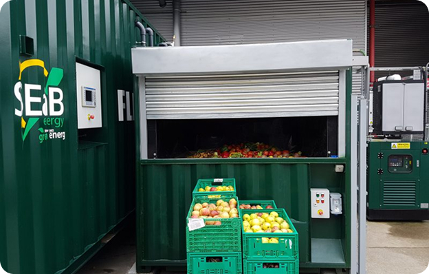 A Flexibuster™ Anaerobic Digestion Unit with food waste inside it and in crates in front of it.