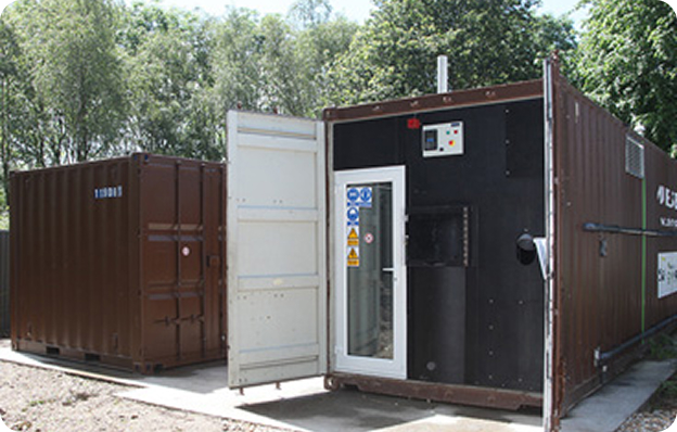 The Muckbuster®, a containerised Anaerobic Digestion unit, with the container door opens, revealing the machinery unit.